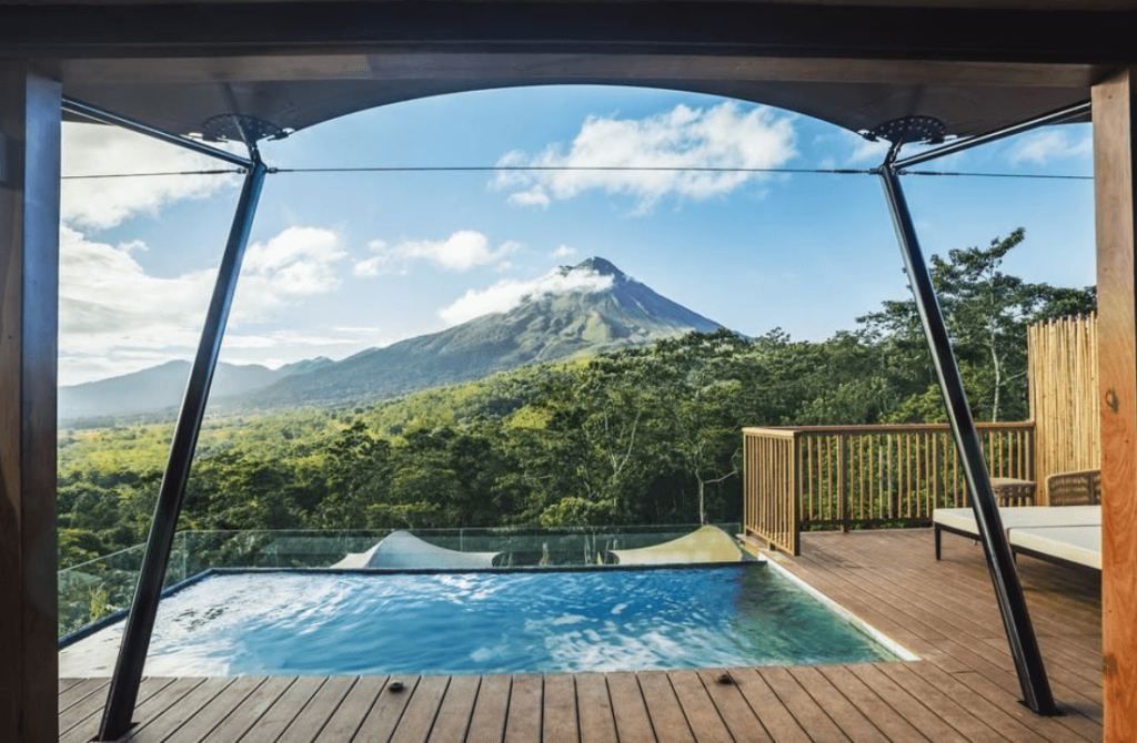 Tented Camp overlooking outdoor pool and Arenal volcano summit